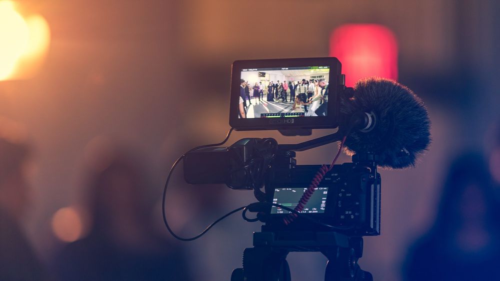 Image of camera filming a diverse group of actors and actresses