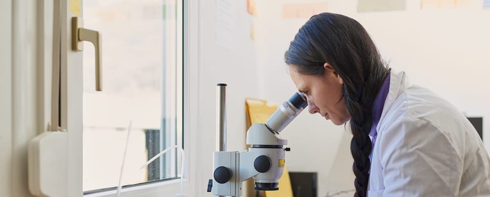 Indigenous scientist using a microscope