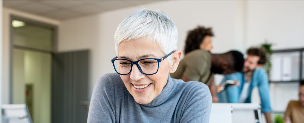 Woman with white short hair looking at laptop