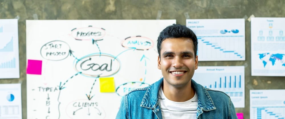 Indigenous leader in front of a goal-setting whiteboard