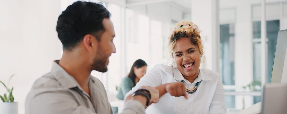 Two engaged employees fistbump