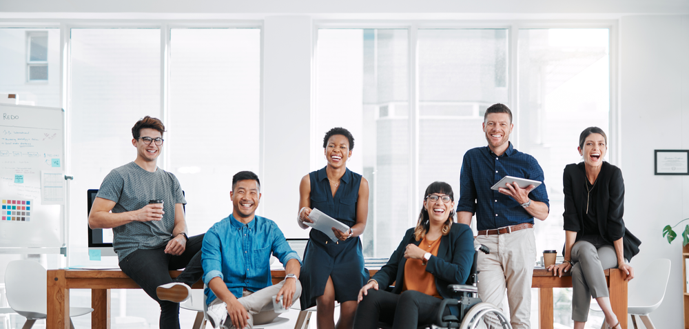 Diverse team facing the camera and smiling in an office