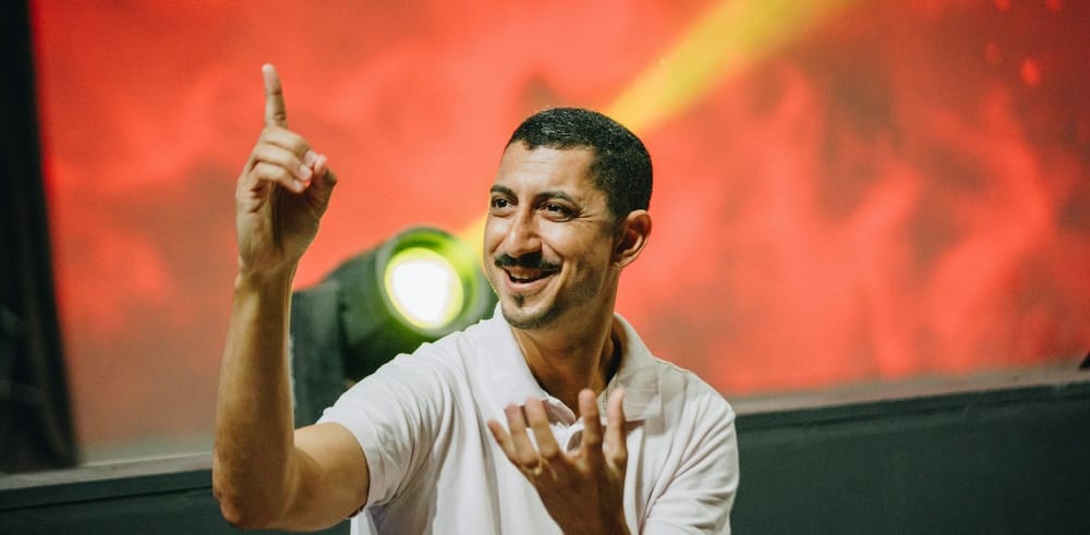 A man communicates with an audience in sign language on a stage