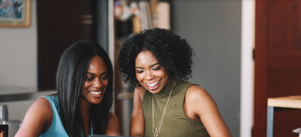 Two Black women looking at a tablet