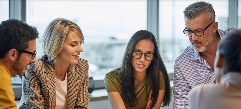 Diverse colleagues planning a campaign around a meeting table