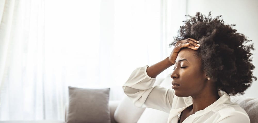 Lonely sad woman deep in thoughts sitting  in the living room with a serious expression