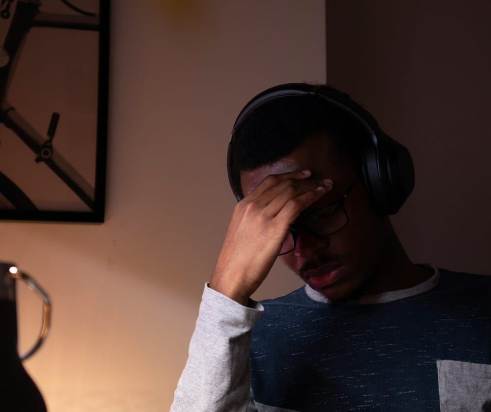 Tired man of color wearing hedphones