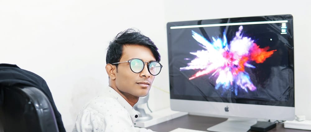 Indian employee looks at the camera, wearing glasses